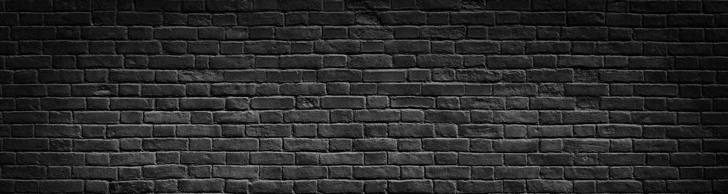 Dark brick wall background with evenly spaced bricks and a textured surface.
