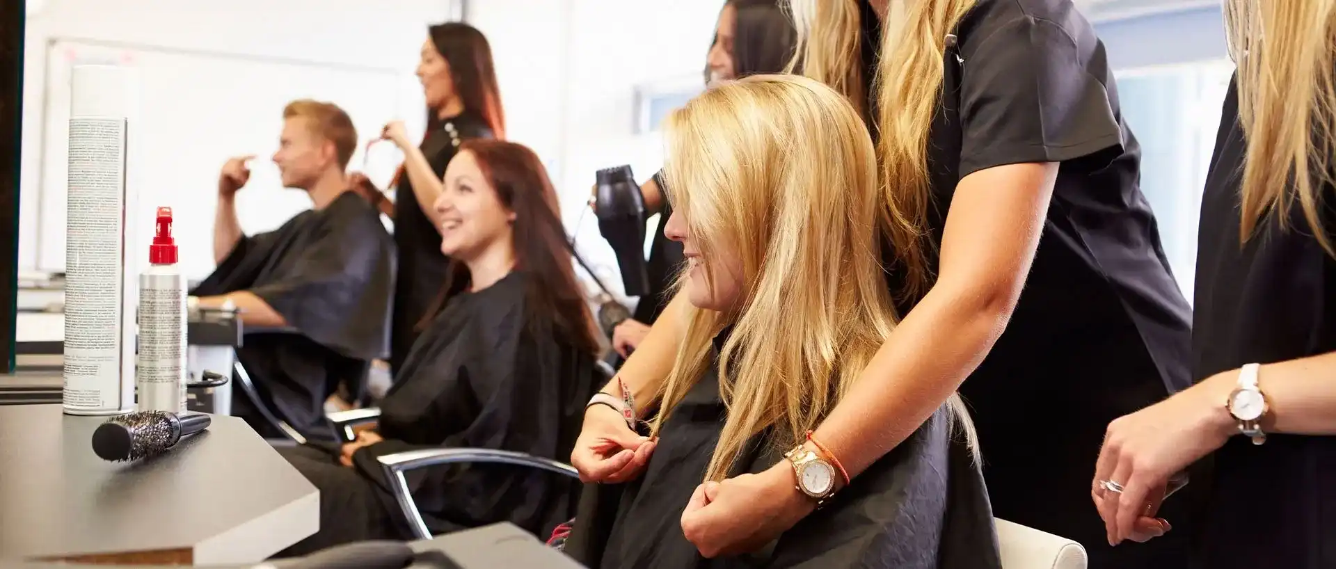 Women getting their hair styled at a busy salon.